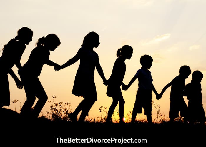 Children holding hands during golden hour.